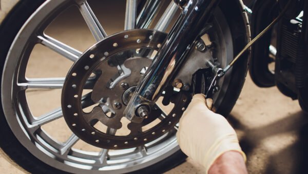 Man fixing bike. Confident young man repairing motorcycle near his garage