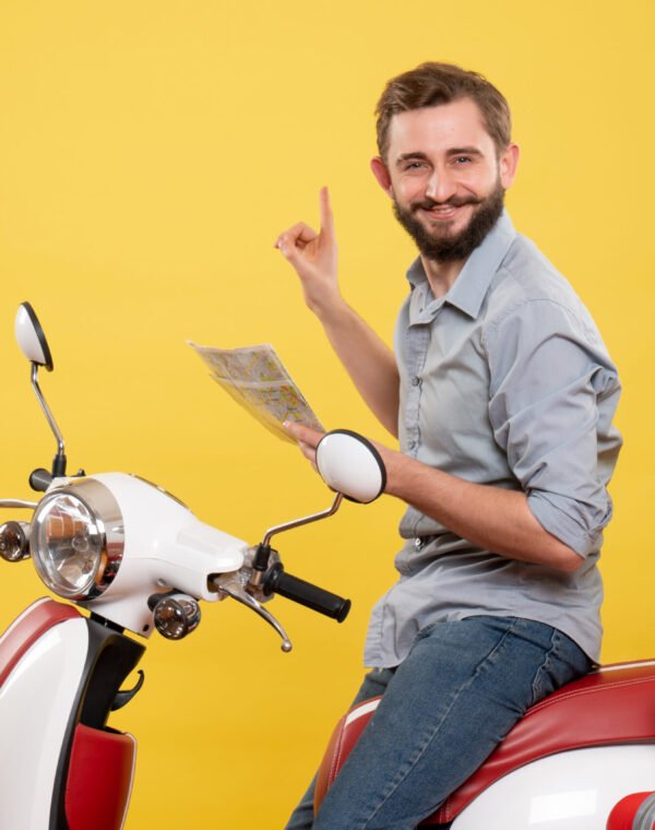 travel-concept-with-smiling-young-man-sitting-motocycle-with-suitcases-it-holding-map-yellow